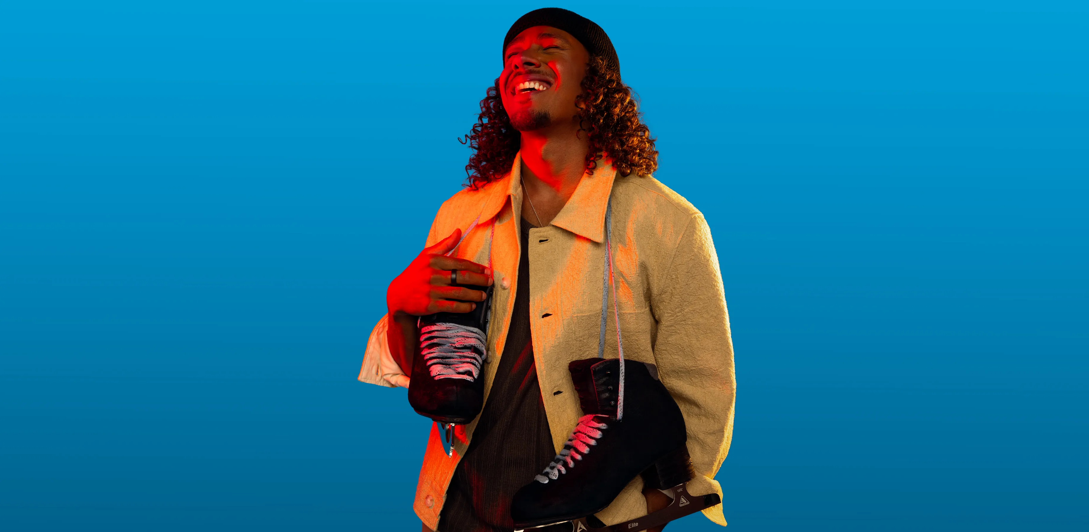 A man holds a football, and looks over his shoulder.